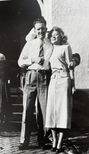 A black and white photo of a man and a woman posing a couple.